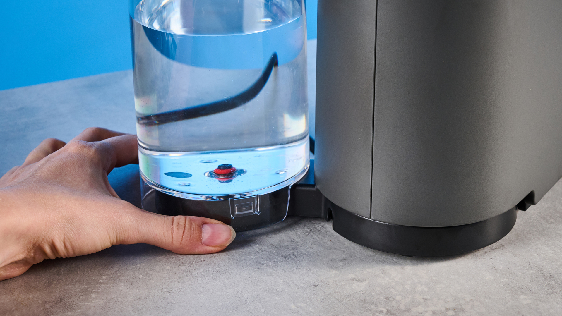 the nespresso vertuo up machine photographed against a blue background
