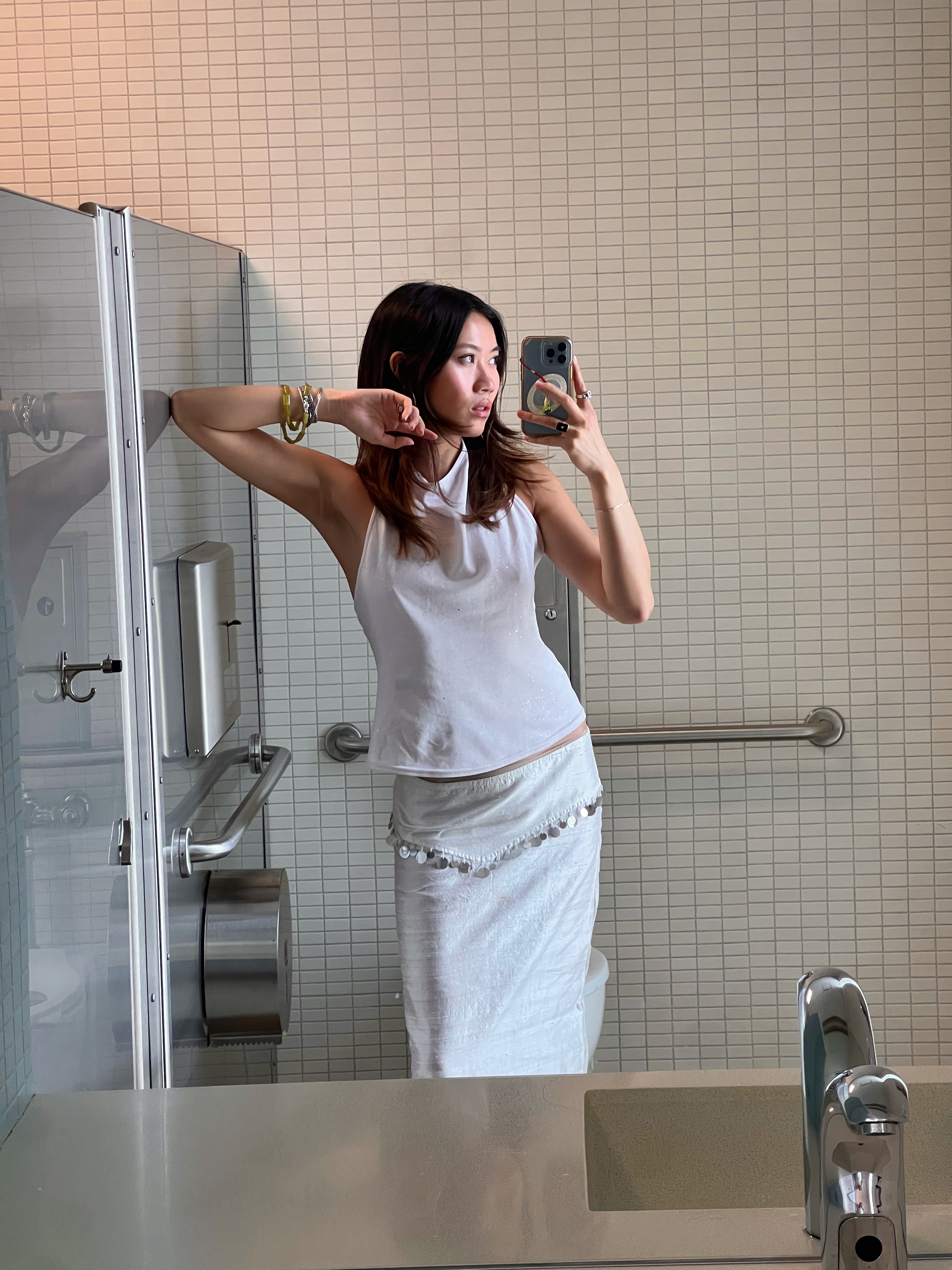 Vivian Li in a white top and white skirt in a mirror selfie