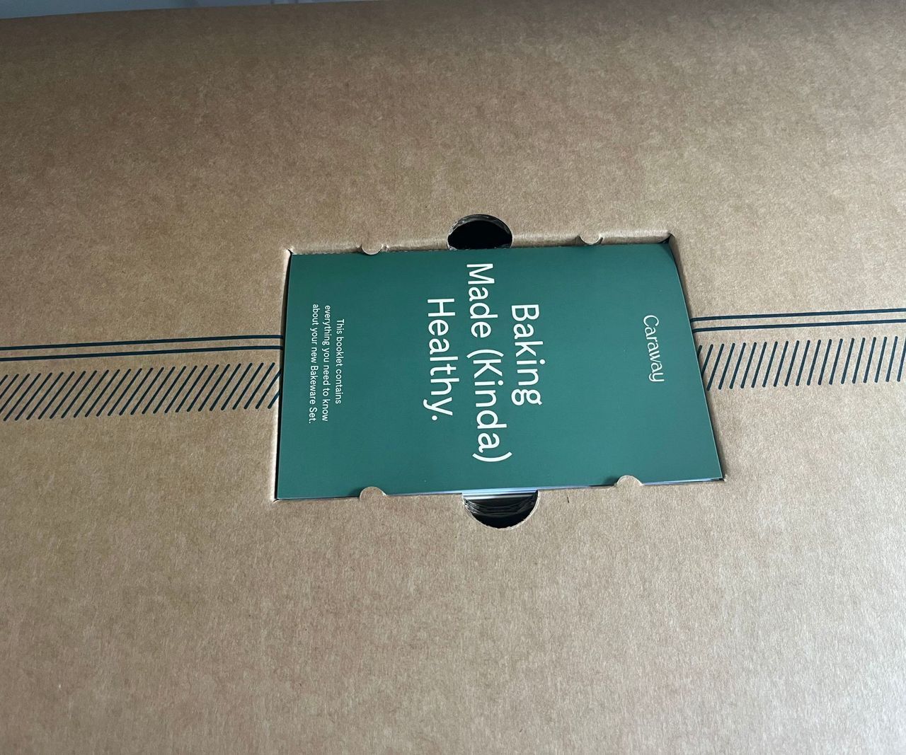 A green instruction manual on top of a cardboard box