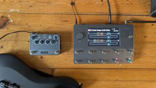 A Neural DSP Quad Cortex and Neural Cortex next to each other on a wooden floor with an electric guitar