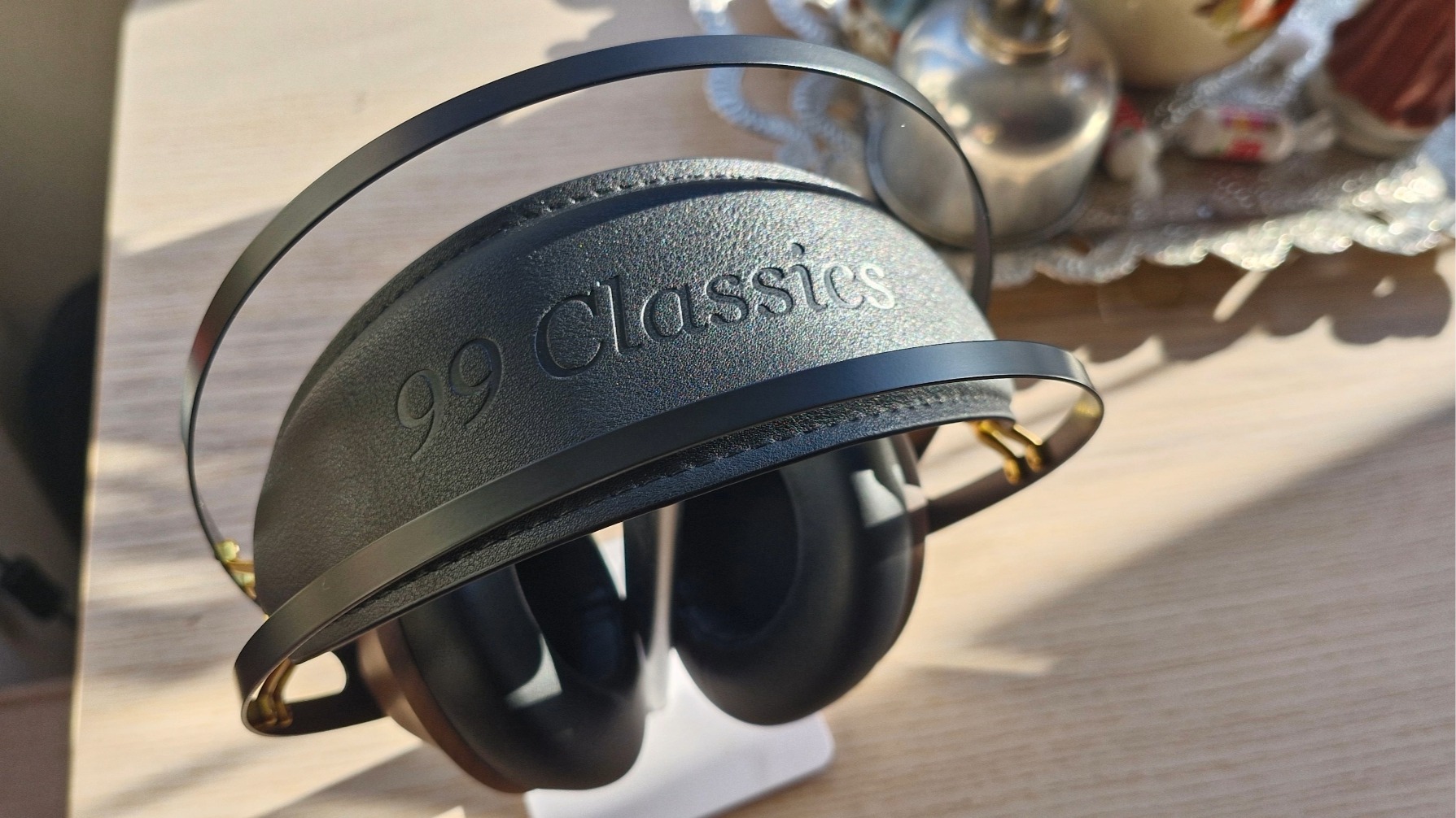 Closeup of the headband of the Meze Audio 99 Classics 2nd Gen over-ear headphones, on a wooden table.
