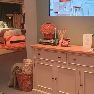 A living room set-up from the John Lewis spring/summer 2025 press showcase with a scalloped rattan table lamp on a white sideboard