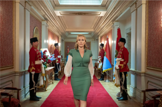 Kate Winslet, as autocratic ruler Chancellor Elena Vernham, walking down a corridor in her palace/HQ with soldiers on either side