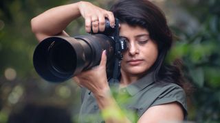 female photographer using one of the best lenses for bird photography