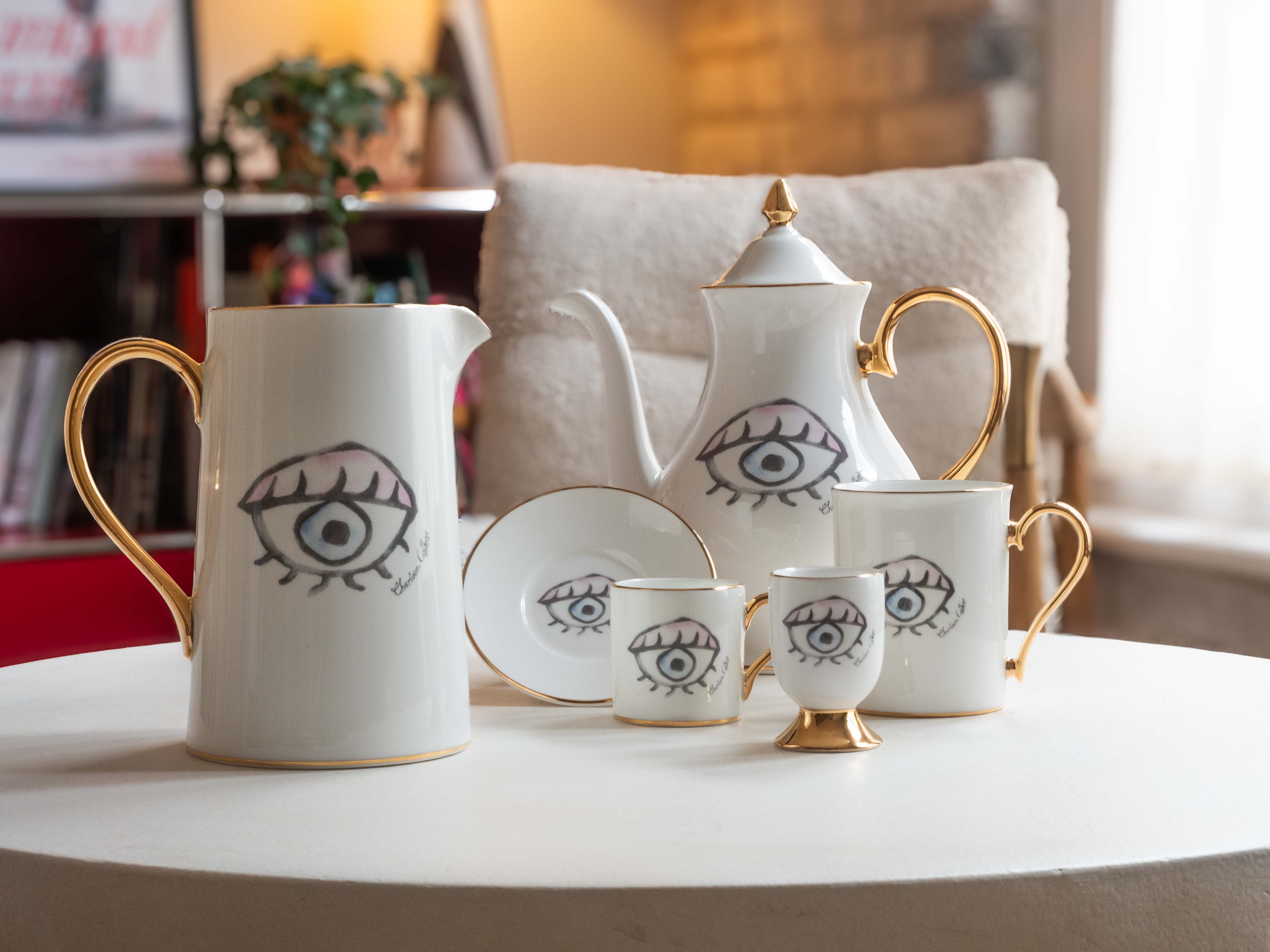 White crockery set with gold highlights, printed with watercolour-style eyeballs