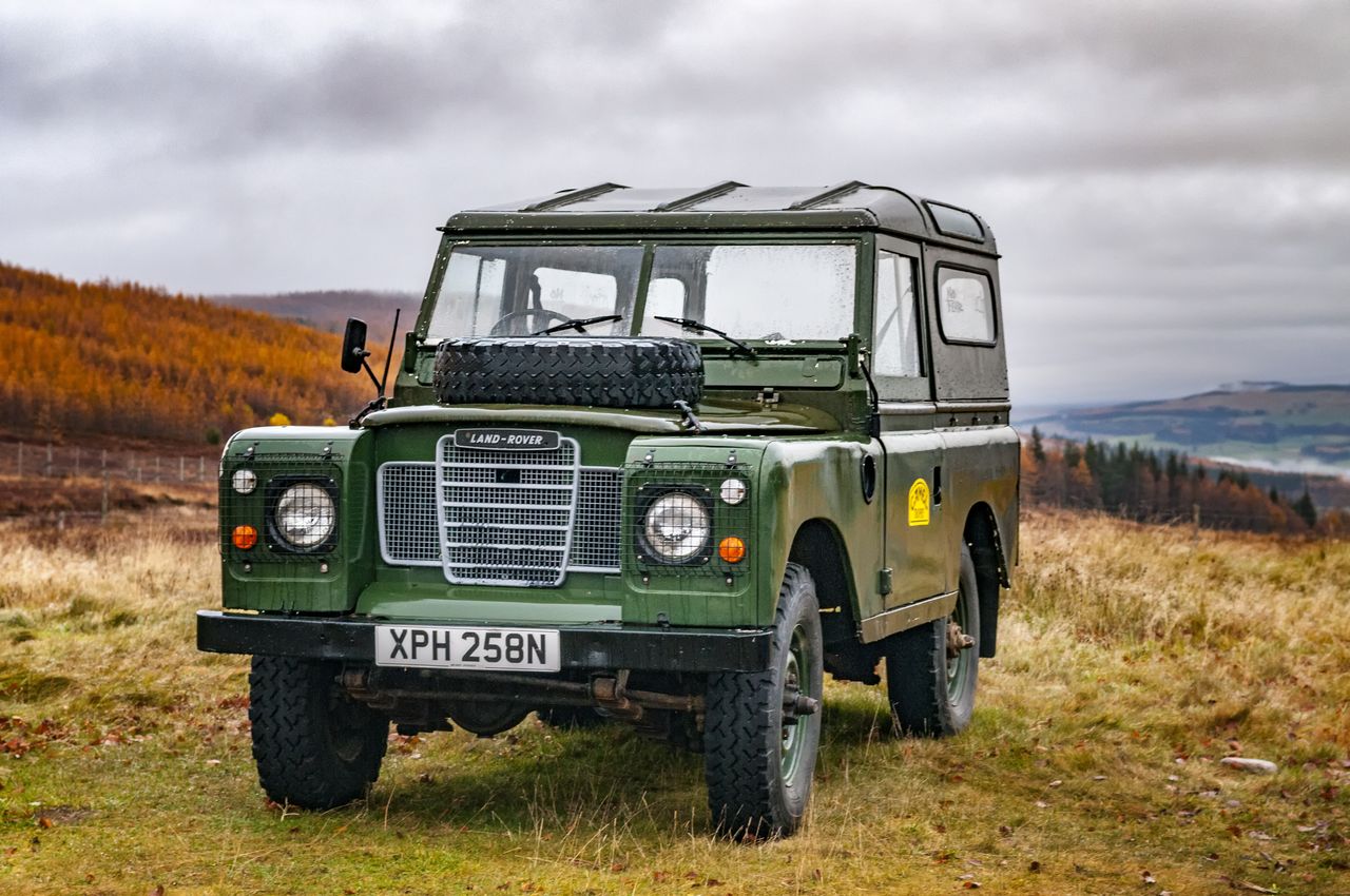 An old Land Rover Defender in its natural habitat: a mountainside in the Scottish Highlands.