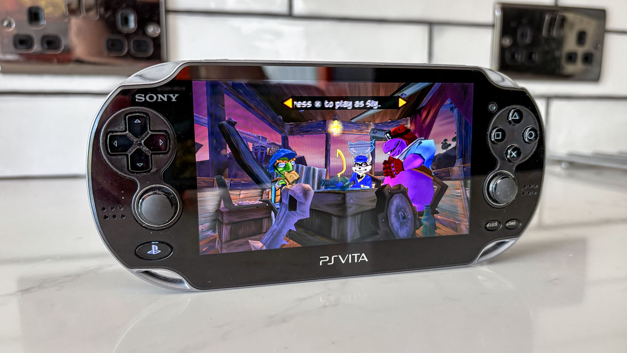 PS Vita on white countertop with Sly Cooper game on display
