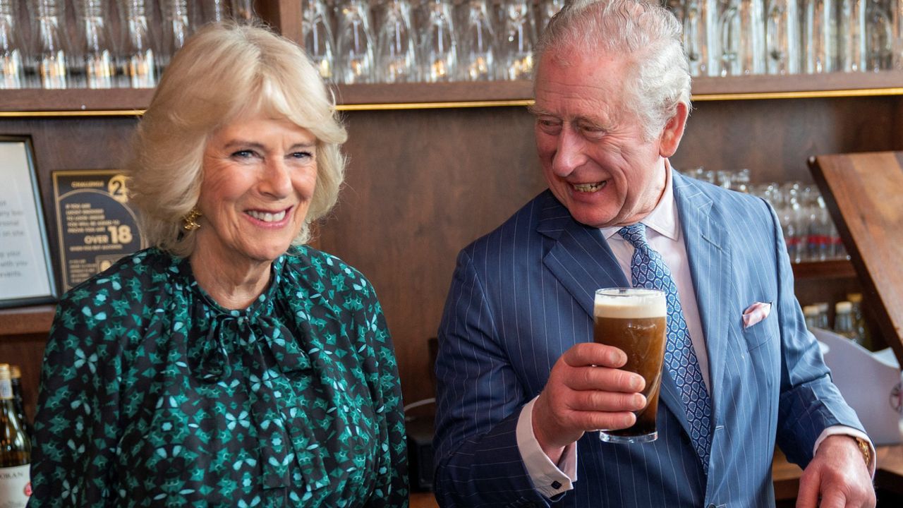 ritain&#039;s Camilla, Duchess of Cornwall (L) reacts as she watches Britain&#039;s Prince Charles, Prince of Wales take a drink of a pint of Guinness that he had poured, during a visit to the Irish Cultural Centre in London on March 15, 2022, to celebrate the centre&#039;s 25th anniversary in the run-up to St Patrick&#039;s Day on March 17.