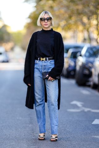a street style influencer wearing blue straight leg jeans with a black jumper