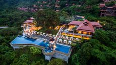 The hotel is set against a backdrop of lush tropical forest