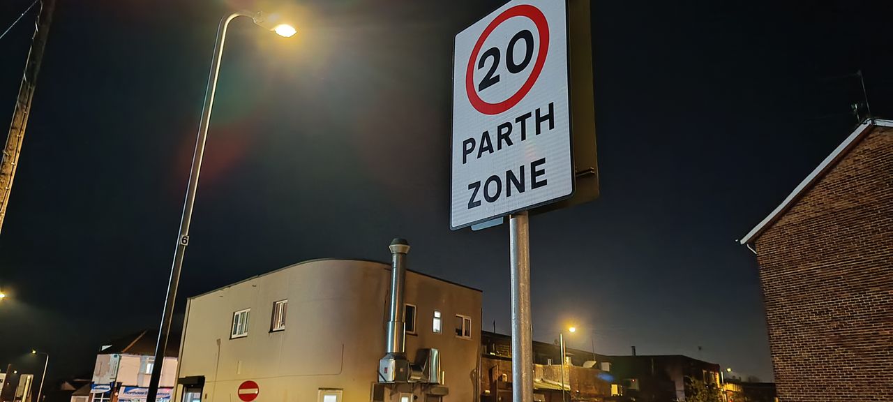 A night shot taken with an Infinix Zero Ultra phone, showing a Welsh 20mph sign in front of some houses