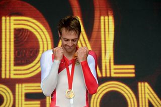 An emotional Alex Dowsett clenches his hands with bowed head as he is awarded gold in the road time trial at the Commonwealth Games.