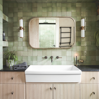 The green tiled bathroom and basin unit of a contemporary-meets-Victorian new build house on three floors in Leytonstone East London, the home of architect couple Alex Wright and Chelsea Nelson and their son.