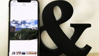 An iPhone next to an Ampersand sign