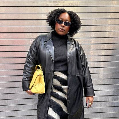 Fashion editor posing in black outfit with yellow bag