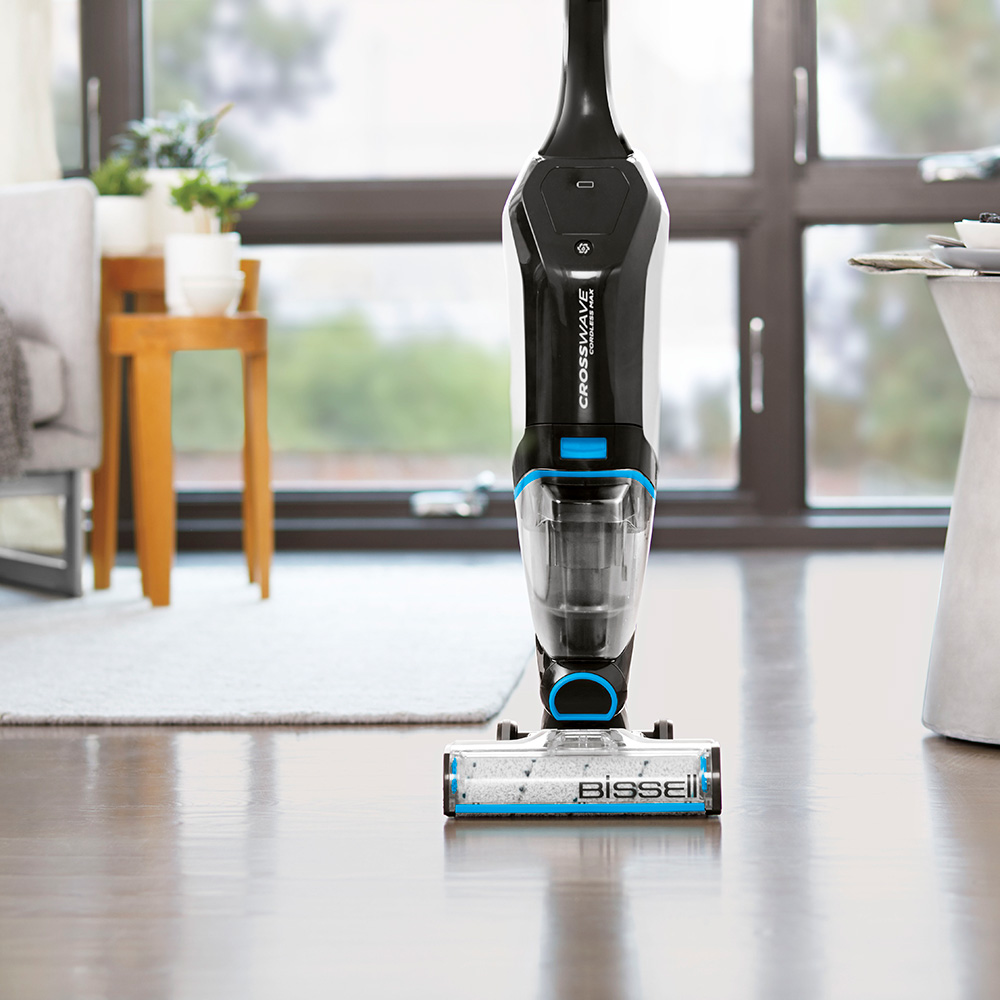 room with wooden flooring and black with blue vacuum cleaner