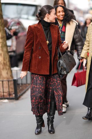 A woman at fashion week in a blazer and printed skirt