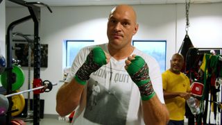 Tyson Fury holding his fists up to the camera at a gym in At Home with the Furys