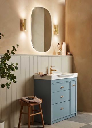 blue vanity unit with mirror above and wall lighting either side