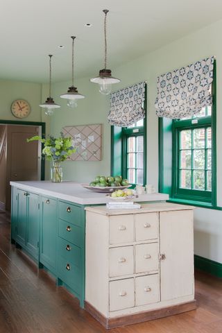 bright green and pink kitchen with island unit with white drawers and green window frames