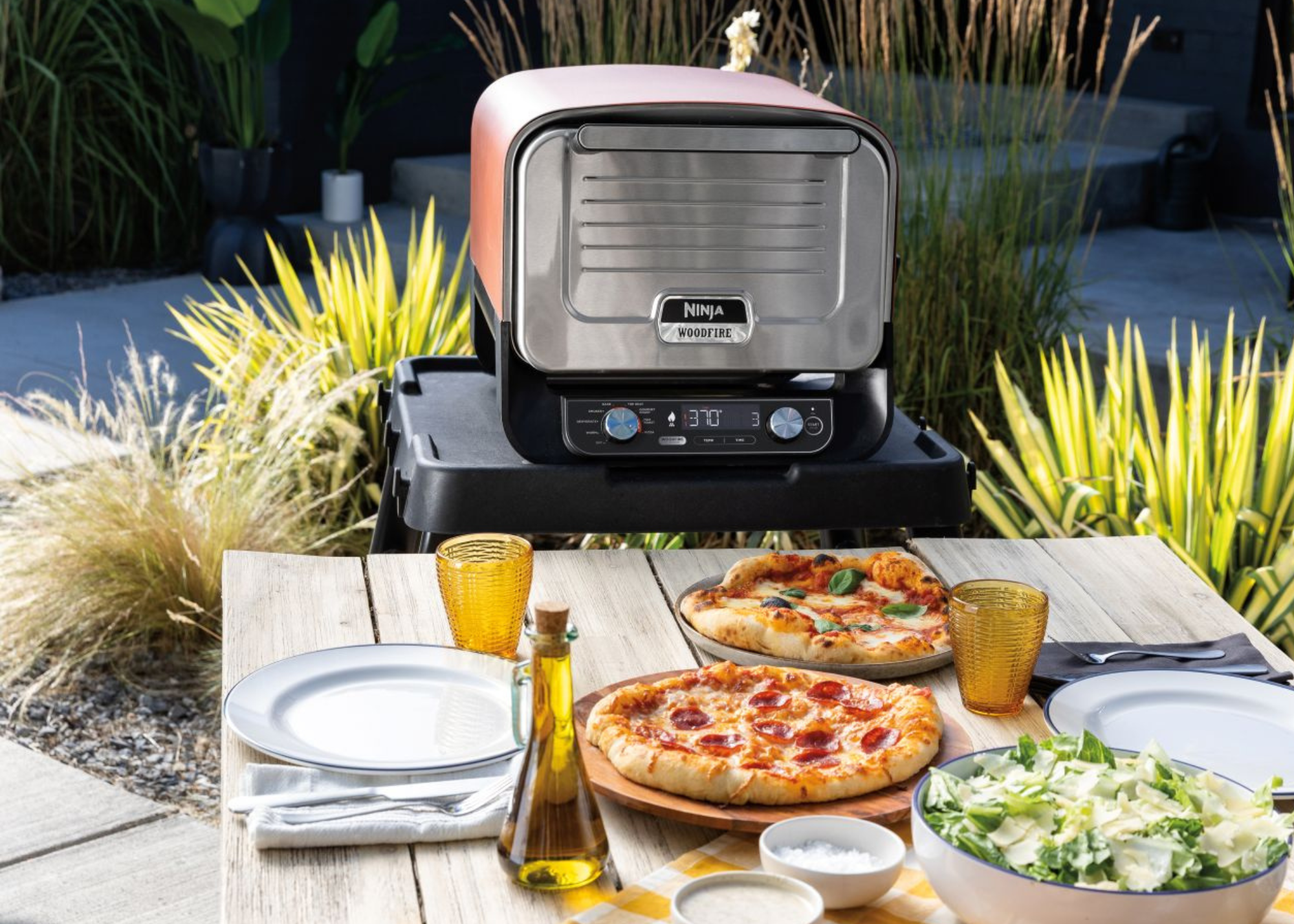 An outdoor dining setting with a red pizza oven