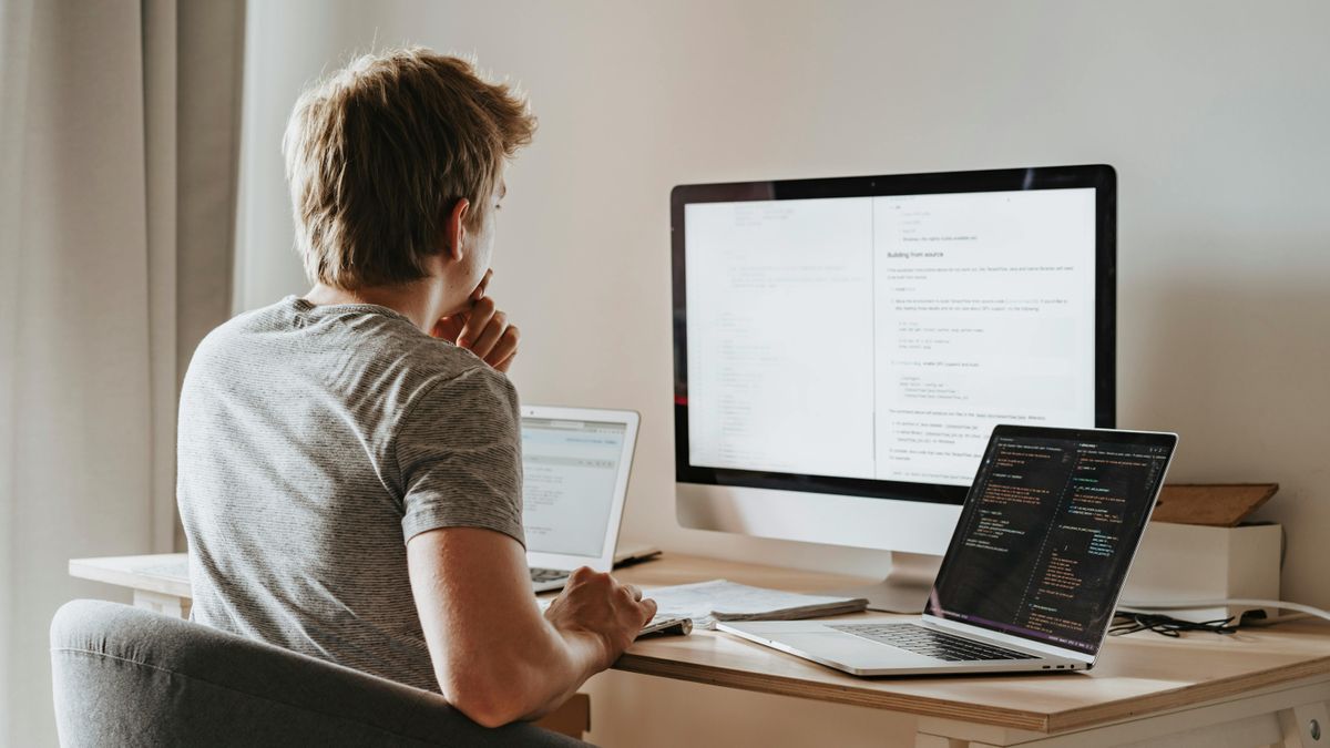 Person looking at three computer screens