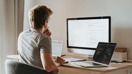 Person looking at three computer screens