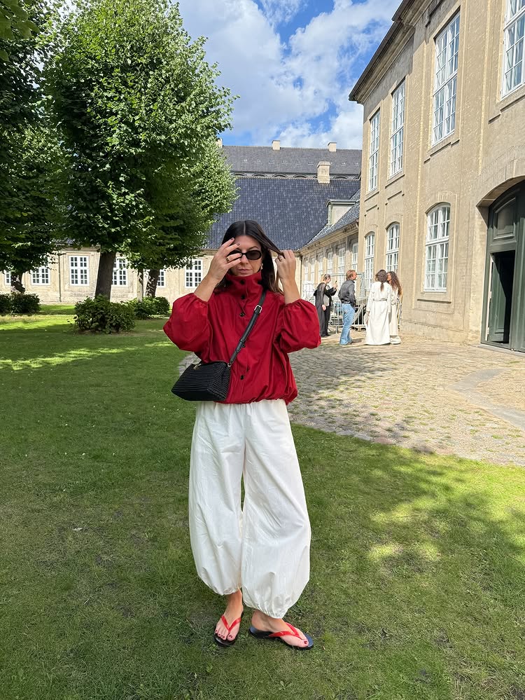 @francescasaffari wears a red jacket with cream geanie pants and red flip flops