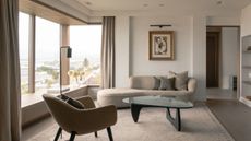 cozy living room with a day bed, a glass coffee table and a piece of art with an art light