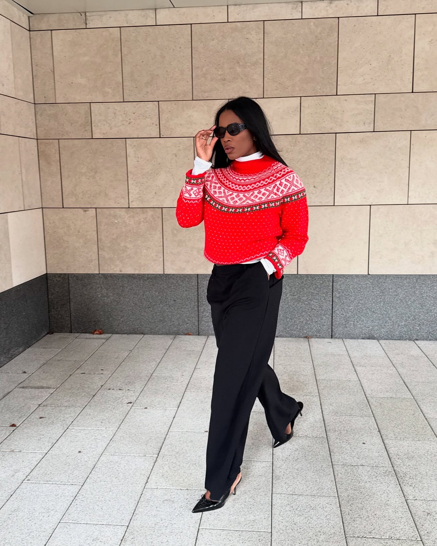 Influencer wearing a red fair isle sweater and black pants