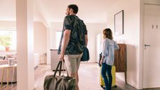 Man and woman with luggage in hotel room, looking around .