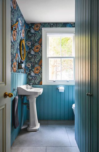 blue panelled bathroom with wallpaper
