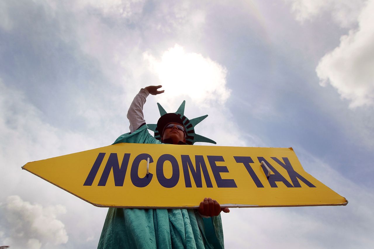 A man holds a sign advertising a tax filing service