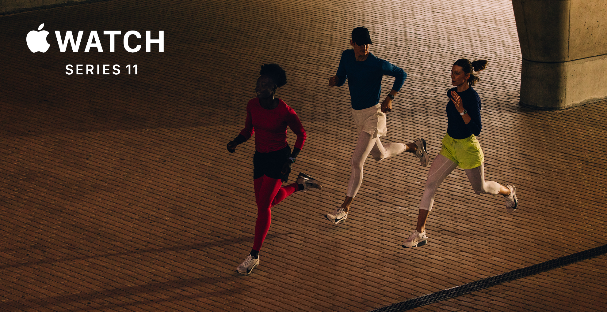 Marketing image for the Apple Watch Series 11 - three people running in what looks like a city street in the evening