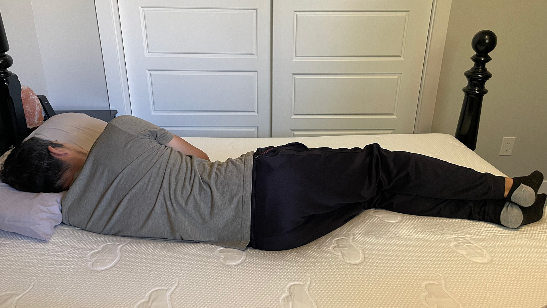 Tester sleeping on his side on a Puffy Cloud mattress in a king