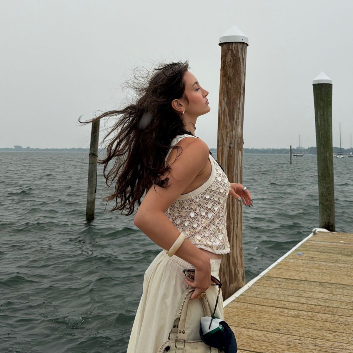 An image of Who What Wear associate beauty editor Alyssa Brascia with wavy hair blowing in the wind.