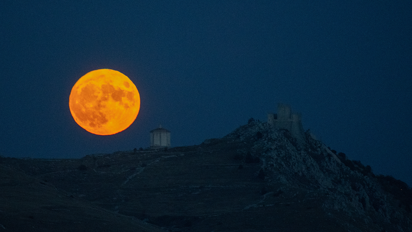 Harvest moon shining behind Rocca Calascio Castle, Abruzzo, Italy on October 1, 2020.