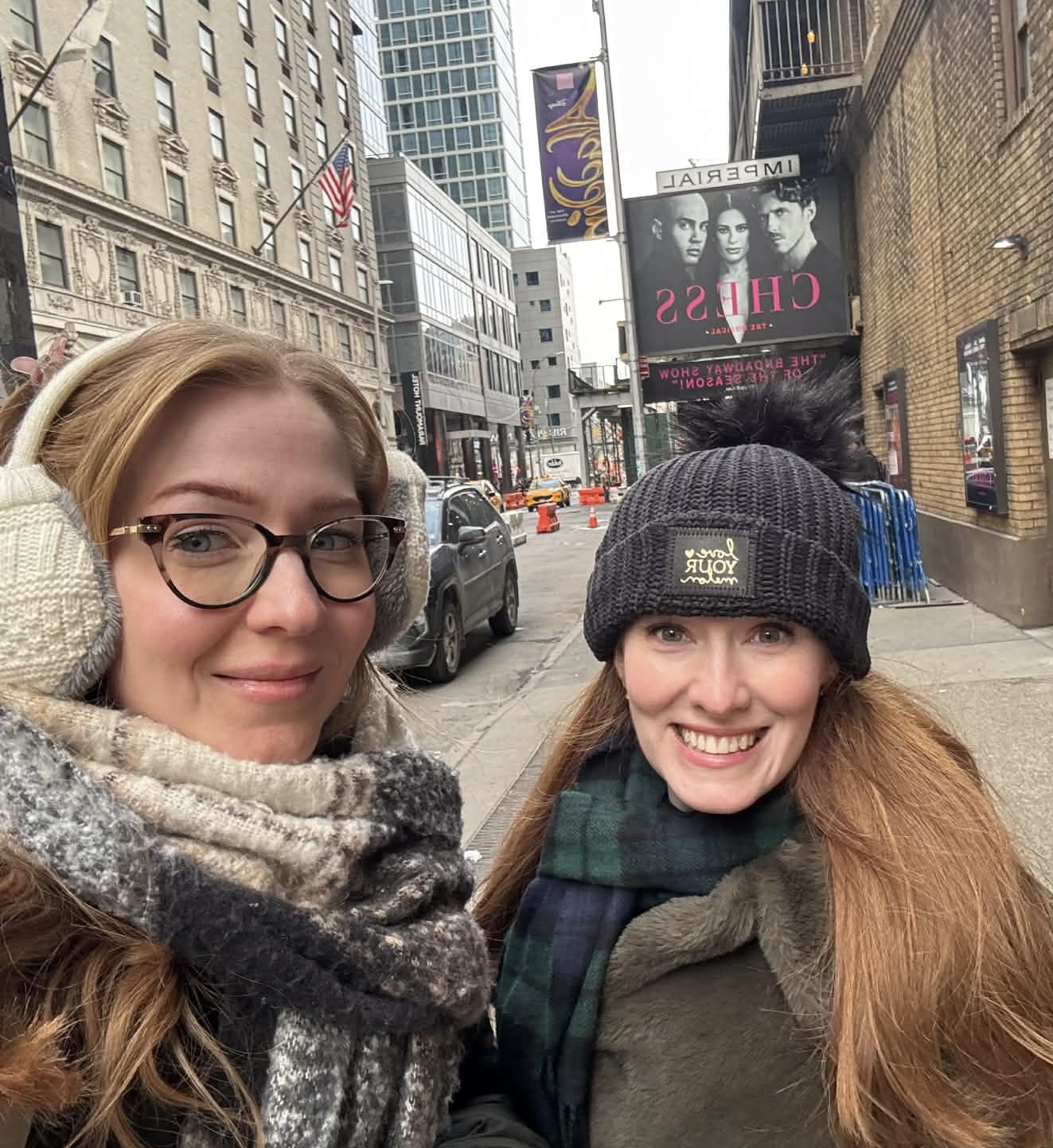 Two women with red hair posing in hats and scarves on a NYC street