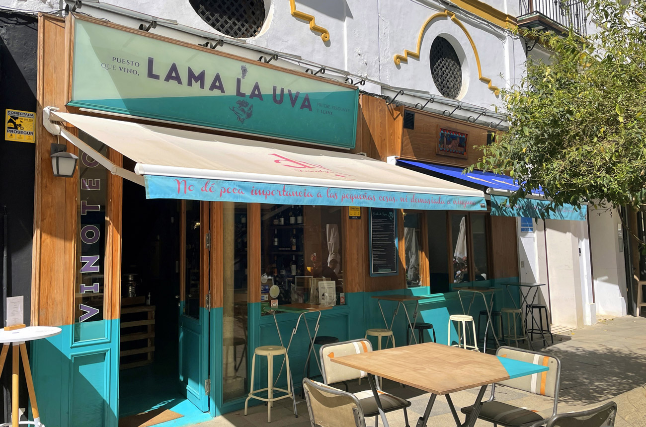 A wine shop with tables on the pavement outside
