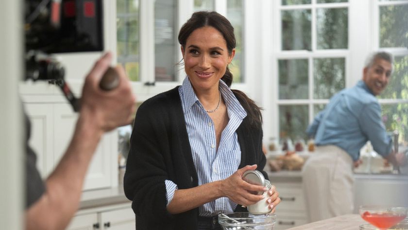 Meghan markle smiling at a guy holding a camera in With Love, Meghan. 