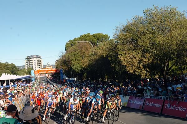 The peloton races under brilliant blue skies in Adelaide, Australia.