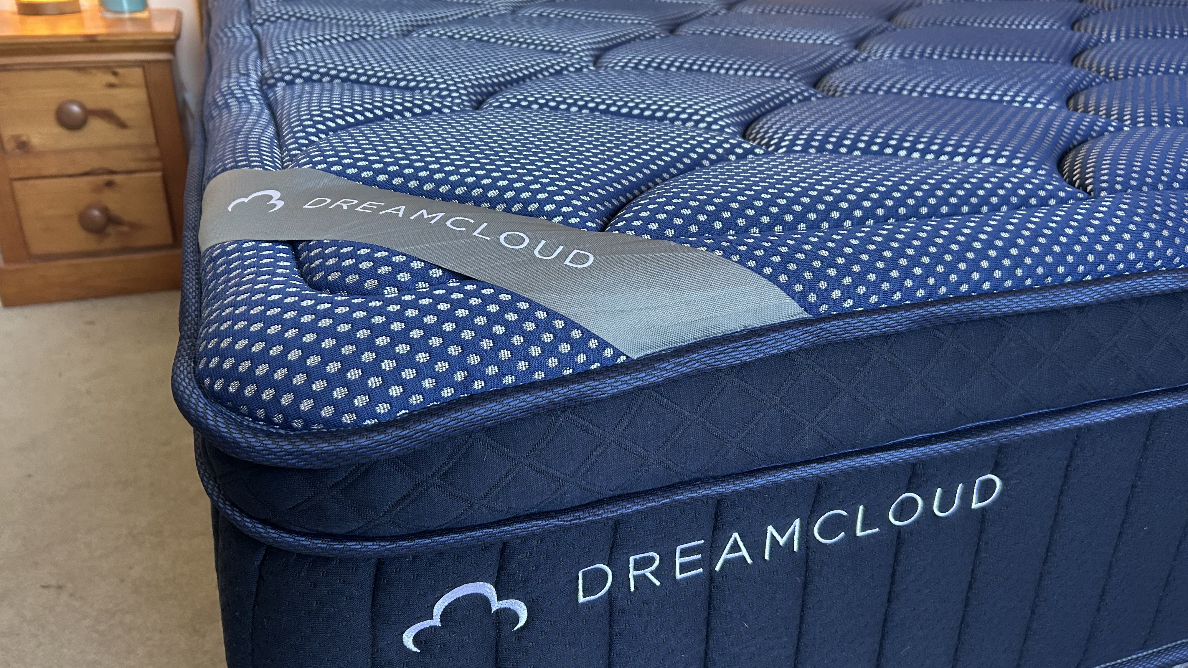 Close detail images of the DreamCloud Luxe Memory Foam mattress, showing design features like the quilted top of the bed and the handles sewn onto the sides