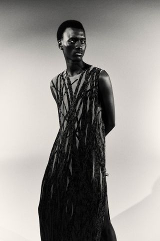 Man in pleated tabard with plant-inspired print by Issey Miyake