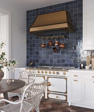 white kitchen with dark blue tiles and gold hood