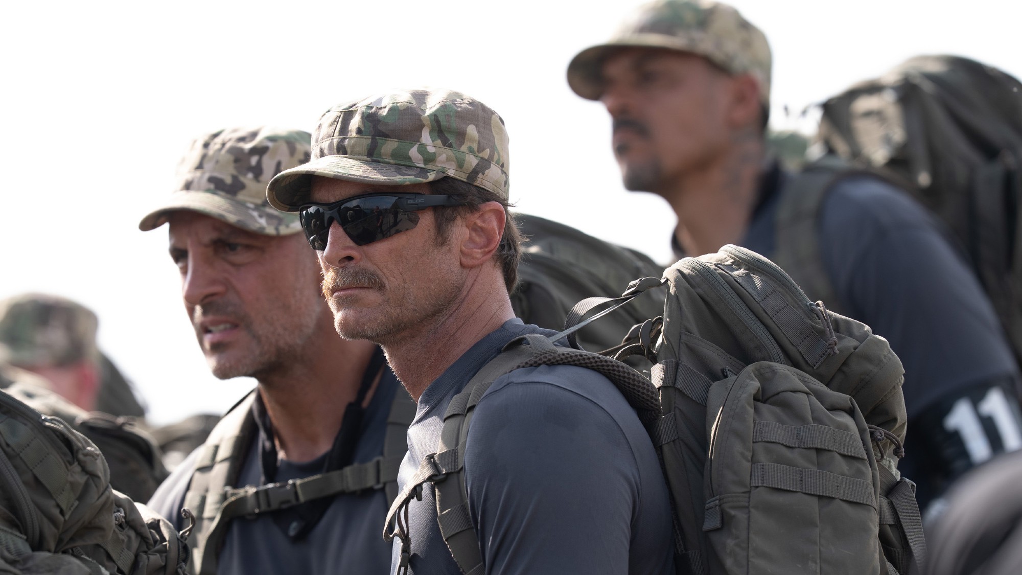 The recruits of Special Forces: World's Toughest Test all watch as their fellow competitors fall from a helicopter. They're wearing recruitment military attire. 