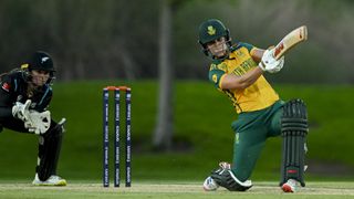 Anneke Bosch of South Africa takes a swing at the ball with the New Zealand wicket keeper just behind, during a women's T20 match.