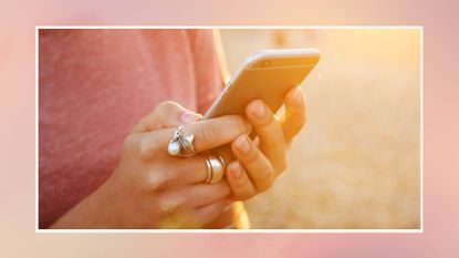 Woman using smartphone at sunset, close up - stock photo