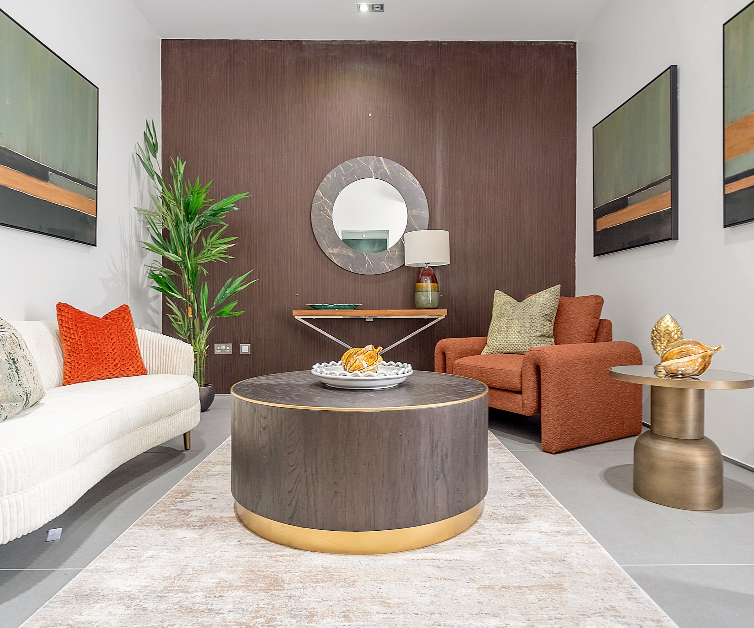 A small living room with a round table and white carpet