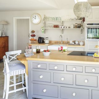 kitchen with wooden countertop grey cabinet and chair