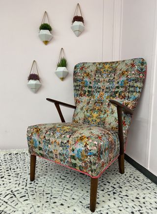 A patterned arm chair in many colours with pink piping